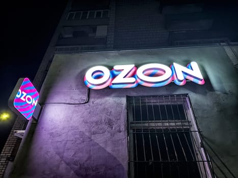 Kirov, Russia - November 28, 2024: Brightly lit 3D logo displayed on a building's exterior at night in a busy city area, highlighting the online marketplace.