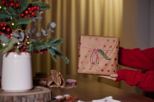 female hands holding Christmas gift box at home, New Year's Eve