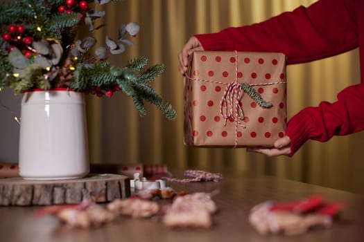 female hands holding Christmas gift box at home, New Year's Eve