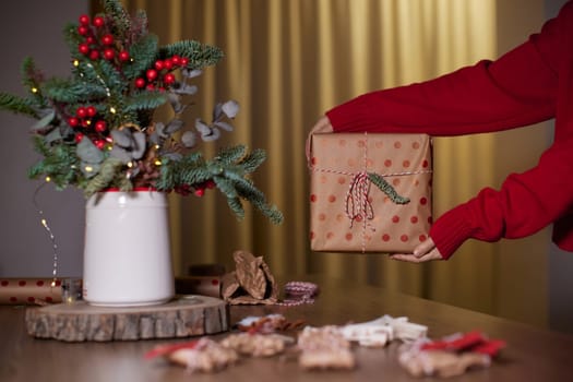 female hands holding Christmas gift box at home, New Year's Eve