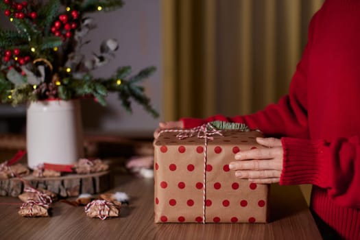 female hands holding Christmas gift box at home, New Year's Eve