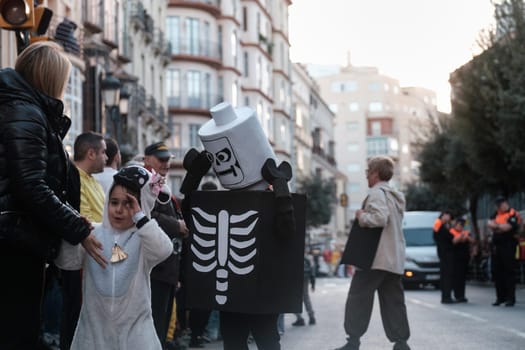 Skeleton Lego minifigure costume at a lively city event. The urban background suggests a festive gathering, with individuals performing various activities and presence of public safety