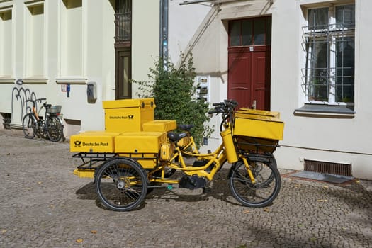 Brandenburg, Germany – September 14, 2024: Bicycle of a letter carrier of Deutsche Post AG, part of the DHL Group in the city center of Brandenburg an der Havel in Germany