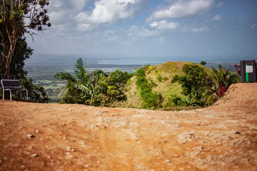 Scenic overlook with bench offers breathtaking views of the valley and the ocean in montana redonda, dominican republic