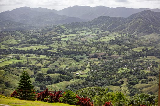 Scenic landscape showcasing the beauty of nature with rolling hills, lush vegetation, and distant mountains in montana redonda, dominican republic
