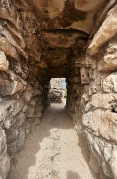 Exploring ancient mayan architecture through a narrow stone passage at the tulum archaeological site in mexico