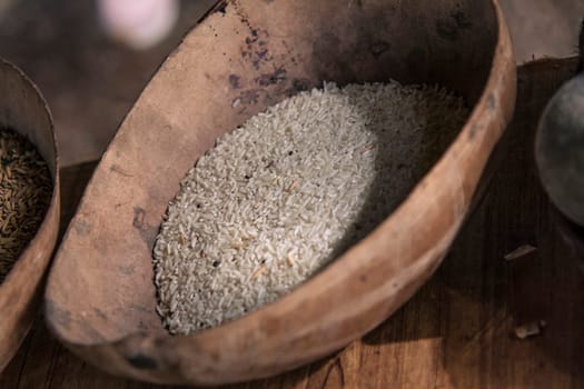 Polished rice grains displayed in a rustic wooden bowl, showcasing a traditional scene from montana redonda, dominican republic