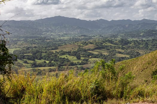 Scenic vista of montana redonda in the dominican republic, showcasing its verdant hills, lush vegetation, and distant mountain range
