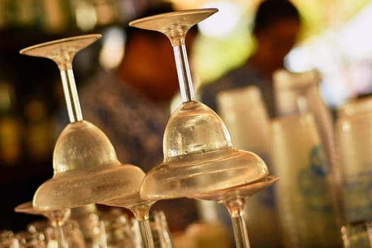 Upside-down cocktail glasses awaiting use on a bar counter, creating an elegant atmosphere