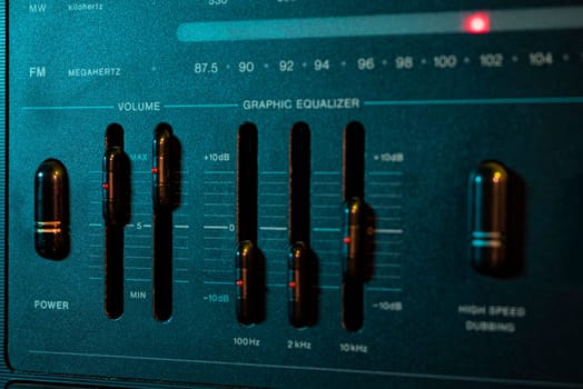 Close-up of a graphic equalizer, adjusting sound levels with volume, frequency, and power controls