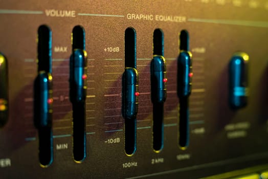 Sliders adjusting sound levels on a graphic equalizer, highlighting audio mixing and sound engineering concepts