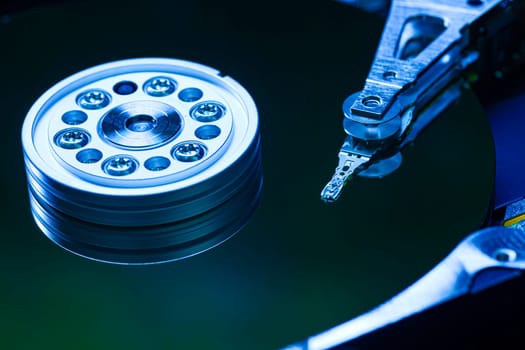Hard disk drive reading data with blue light reflecting on its surface