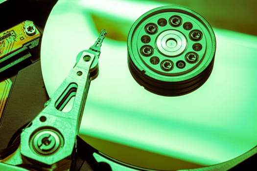 Hard disk drive reading data with green light, close-up view of magnetic head