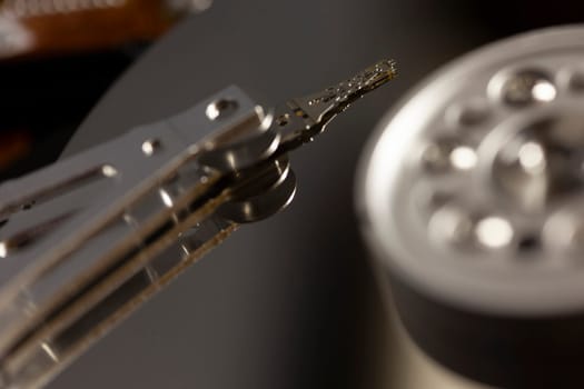Close-up of a computer hard disk drive's reading head scanning the platter, highlighting the intricate mechanics of data storage and retrieval