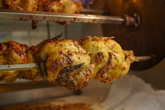 Delicious rotisserie chickens roasting on a spit in a commercial oven, ready to be served
