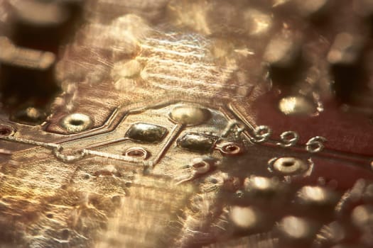Close-up of a circuit board bathed in golden light, highlighting the intricate details of its electronic components