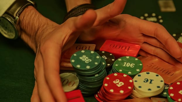 Gambler protecting his poker chips during a game in a casino