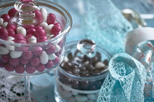 Pink and white jordan almonds in elegant glass containers, adding a touch of sweetness to a festive candy buffet table