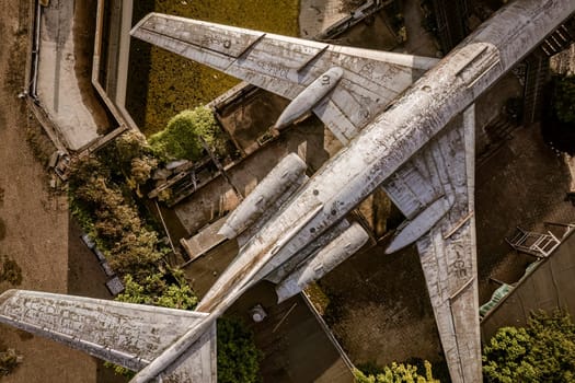Aerial view of decaying airplane placed on top of building, showing concept of urban decay and post-apocalyptic scenario