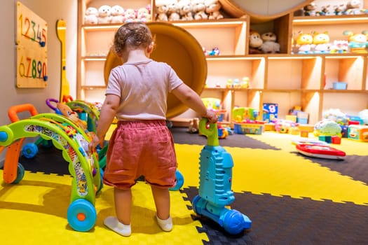 Toddler playing with educational toys in a colorful playroom for fun and learning