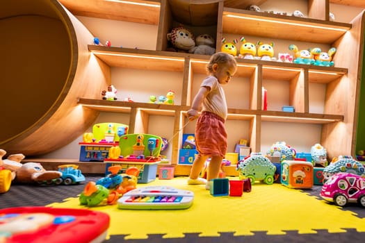 Toddler enjoying a playful and creative indoor environment filled with toys, games, and engaging activities for learning and fun