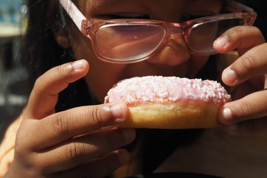 child mouth eating chocolate donuts .