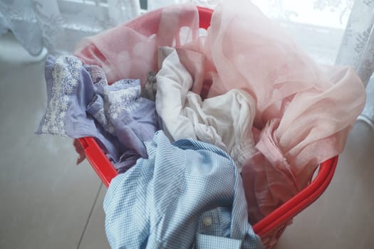 A colorful mix of clothes arranged in a basket, softly illuminated by natural light
