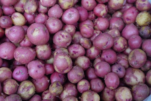 A vibrant and colorful assortment of fresh red potatoes beautifully piled together