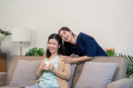 Two friends share a joyful moment over coffee in a cozy living room highlighting the warmth of friendship.