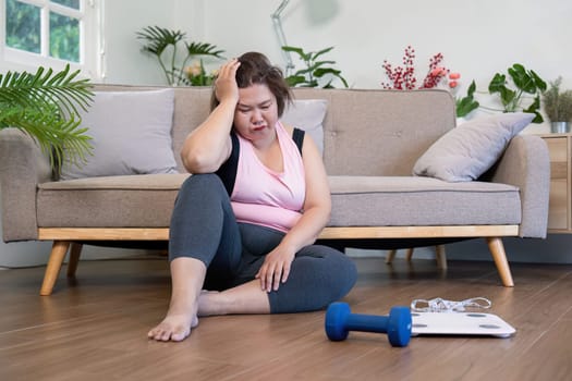 A woman contemplates her weight loss journey at home feeling the emotional weight of her fitness challenges.