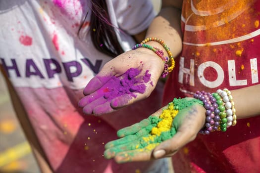 Hands / Palms of people covered in colorful Holi festival gulal powder. Happy Holi Indian festival of colors.