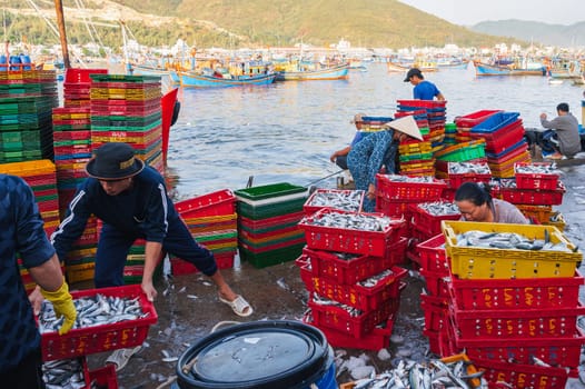Asian sellers unload and sell fresh fish at the fish market. Vietnam, Nha Trang - September 8, 2024