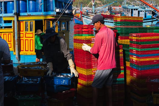 Vietnamese workers working at the fish market. In the morning, these people were unloading boxes of fresh fish. Vietnam, Nha Trang - September 8, 2024