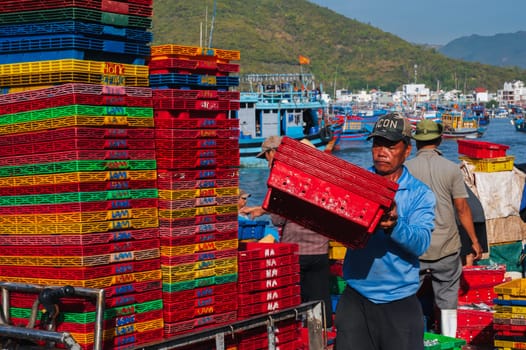 Asian fishermen unload their catch at the fishing port in Nha Trang. Vietnam, Nha Trang - September 8, 2024