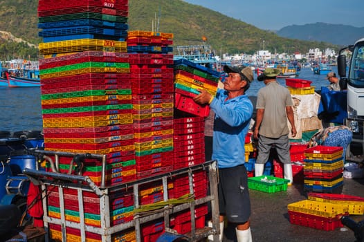 Asian fishermen unload their catch at the fishing port in Nha Trang. Vietnam, Nha Trang - September 8, 2024