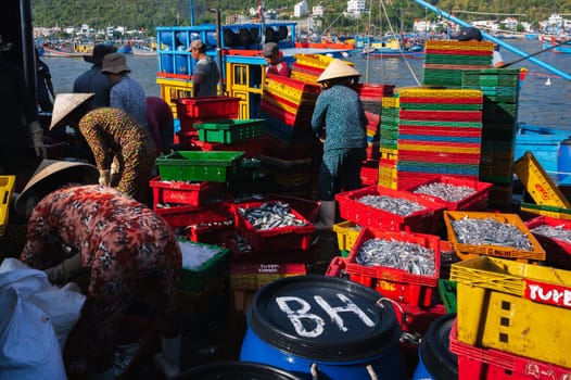Local Vietnamese residents work at the fish market, unloading boxes from ships. Vietnam, Nha Trang - September 8, 2024