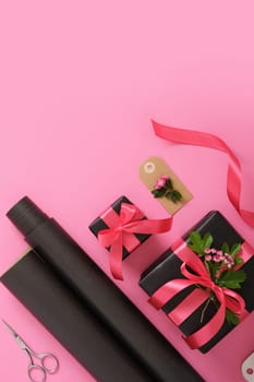 Gift wrapping. Brown craft wrapping paper, pink ribbon, scissors, hawthorn flowers. Copyspace