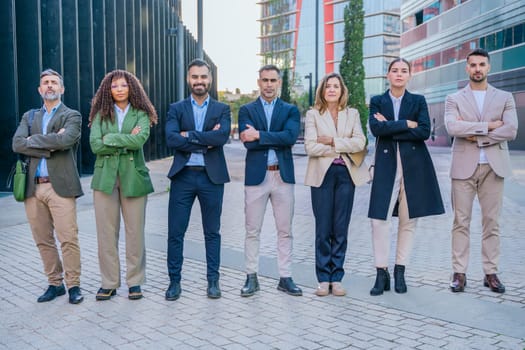 A diverse group of business professionals confidently standing outdoors with their arms crossed. The image conveys professionalism, teamwork, confidence, and modern business attitudes, perfect for corporate themes.