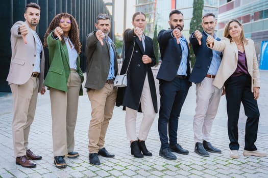 Group of confident business professionals pointing forward in a modern urban environment. Represents leadership, teamwork, motivation, and collaboration in the corporate world.