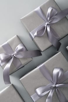 Silver gift boxes with gray ribbons on a black background.