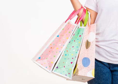 Happy woman hand holding shopping bags multicolor, young female hold many packets within arms isolated on white background, Black friday sale concept