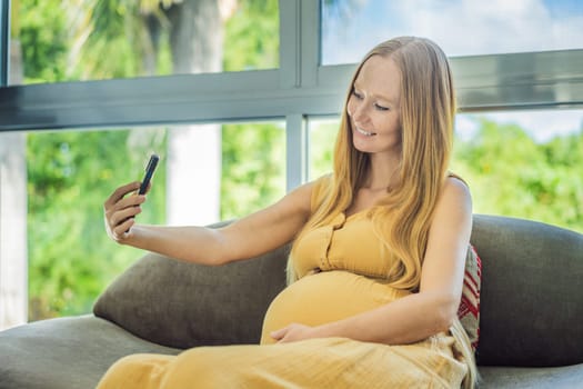 Beautiful woman holding pregnant belly and using phone, calling friends or family via video call.