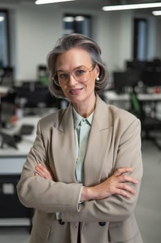 Portrait of an attractive mature caucasian woman with arms crossed on her chest in the office