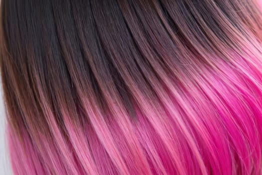This close-up photo accentuates the vibrant allure of pink hair in an ombre design, revealing a harmonious fusion of colors and textures