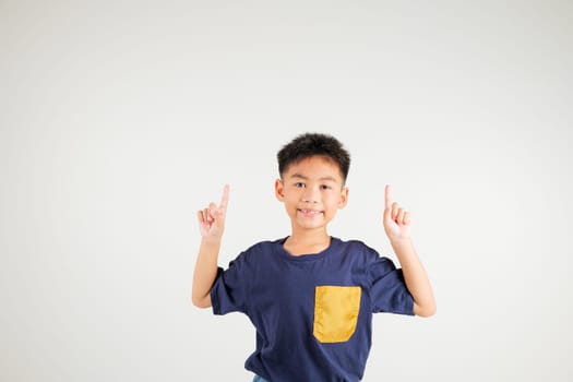 Asian happy portrait cute young kid boy makes gesture fingers point upwards above presenting product something, studio shot isolated on white background, primary children man smile