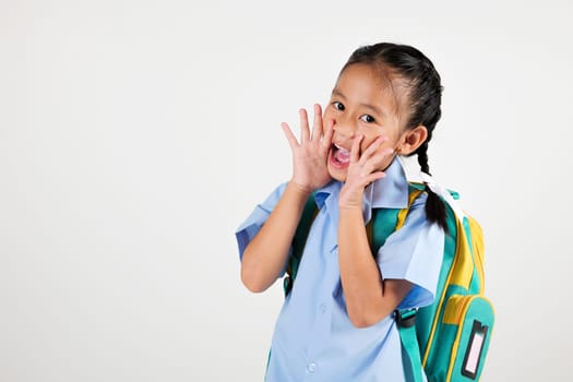 Portrait smile Asian little girl kindergarten hold hands open mouth make shout speak loud announcement studio isolated white background, happy woman kid wear school uniform screaming, back to school
