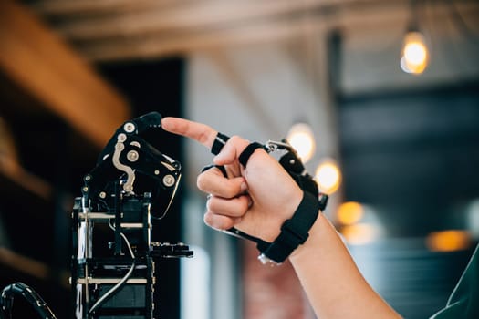 Enthusiastic Asian teen boy explores technology testing a robot hand and arm in a technical college for educational advancement. Embracing AI and humanity in futuristic learning.
