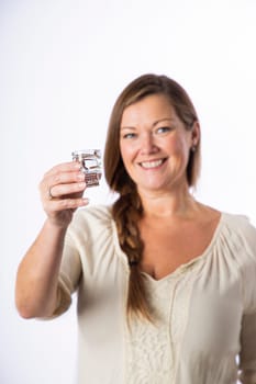 Forty something woman, wearing casual clothes, offering a shot of alcohol, from a skull shooter glass