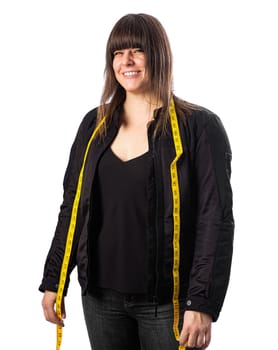 Forty something woman wearing a black biker coat and a yellow measuring tape,, against a white background