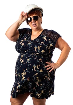Fifty something woman wearing a short dress, hard hat and sunglasses against a white background